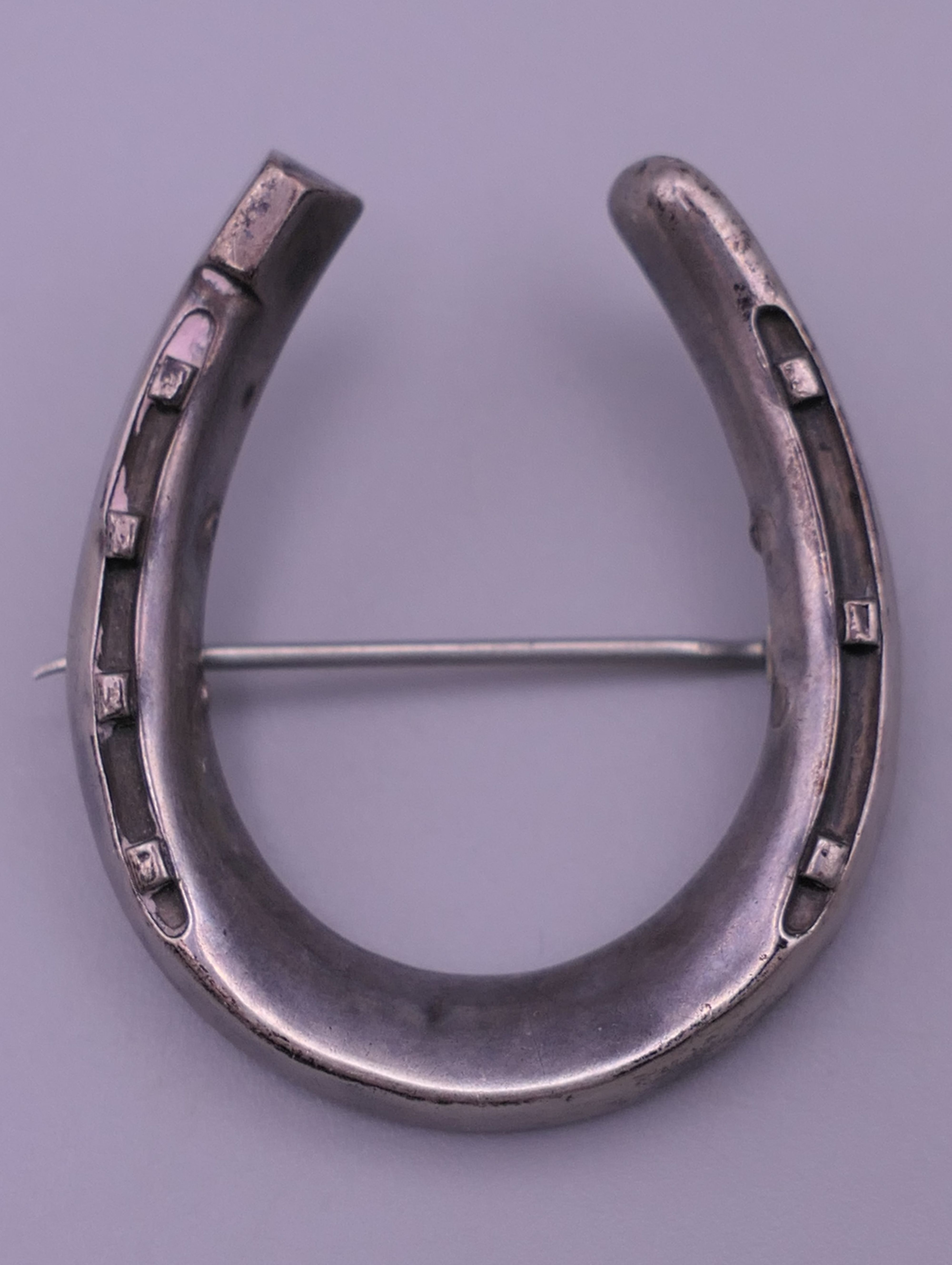 A silver locket, a white metal (silver) horseshoe brooch and a butterfly brooch. - Image 8 of 9