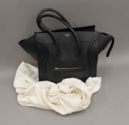 A Celine luggage tote (large size) black leather bag and cover. 30 cm wide.