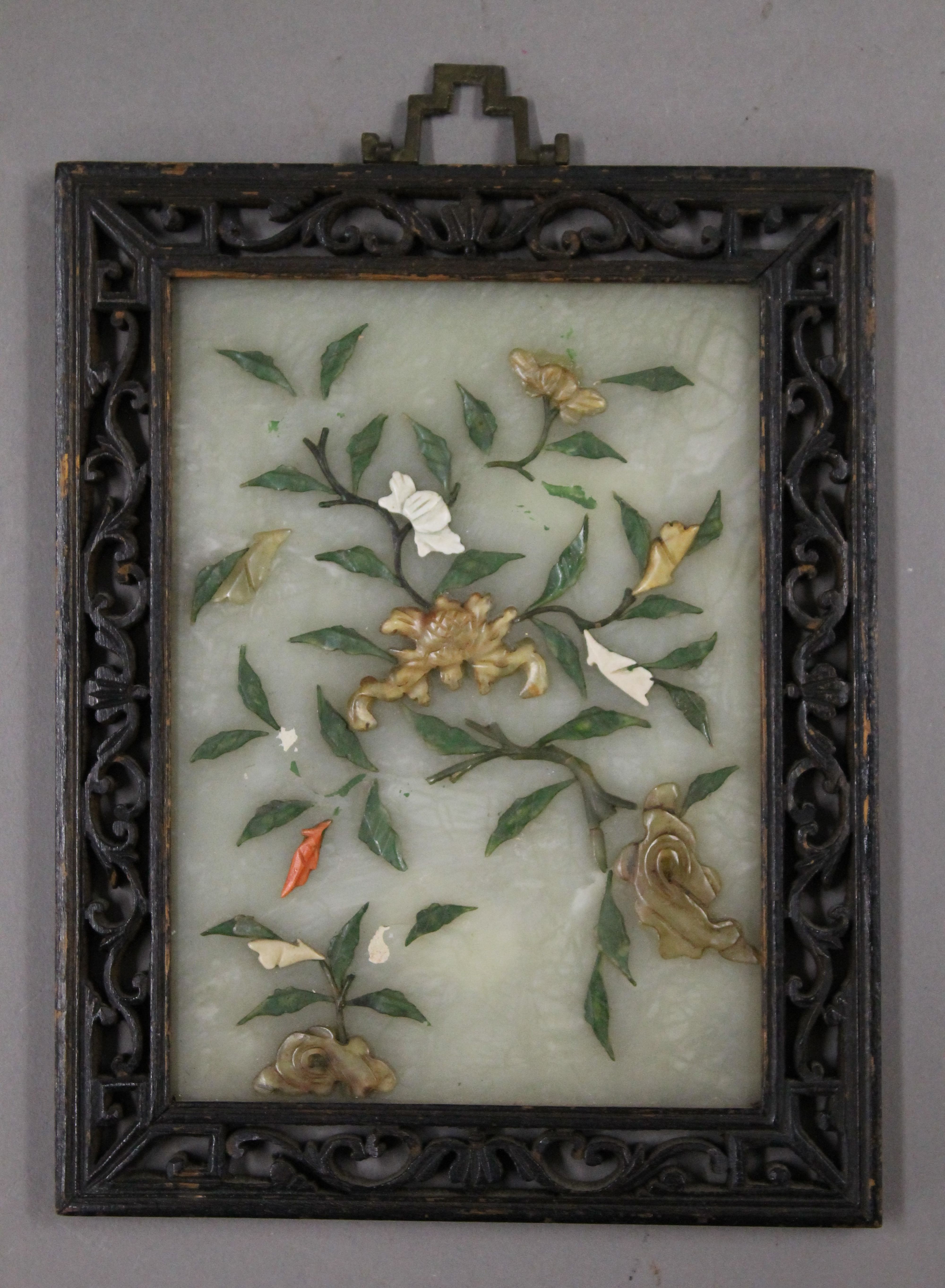 A Chinese hardstone mounted jade plaque in a carved wooden frame. 15 x 19 cm overall.