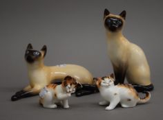 Four Royal Doulton models of cats. The largest 14 cm high.