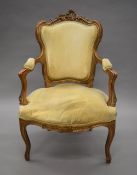A 19th century carved gilt wood open arm chair. 61 cm wide.