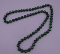 A string of malachite beads. 82 cm long.