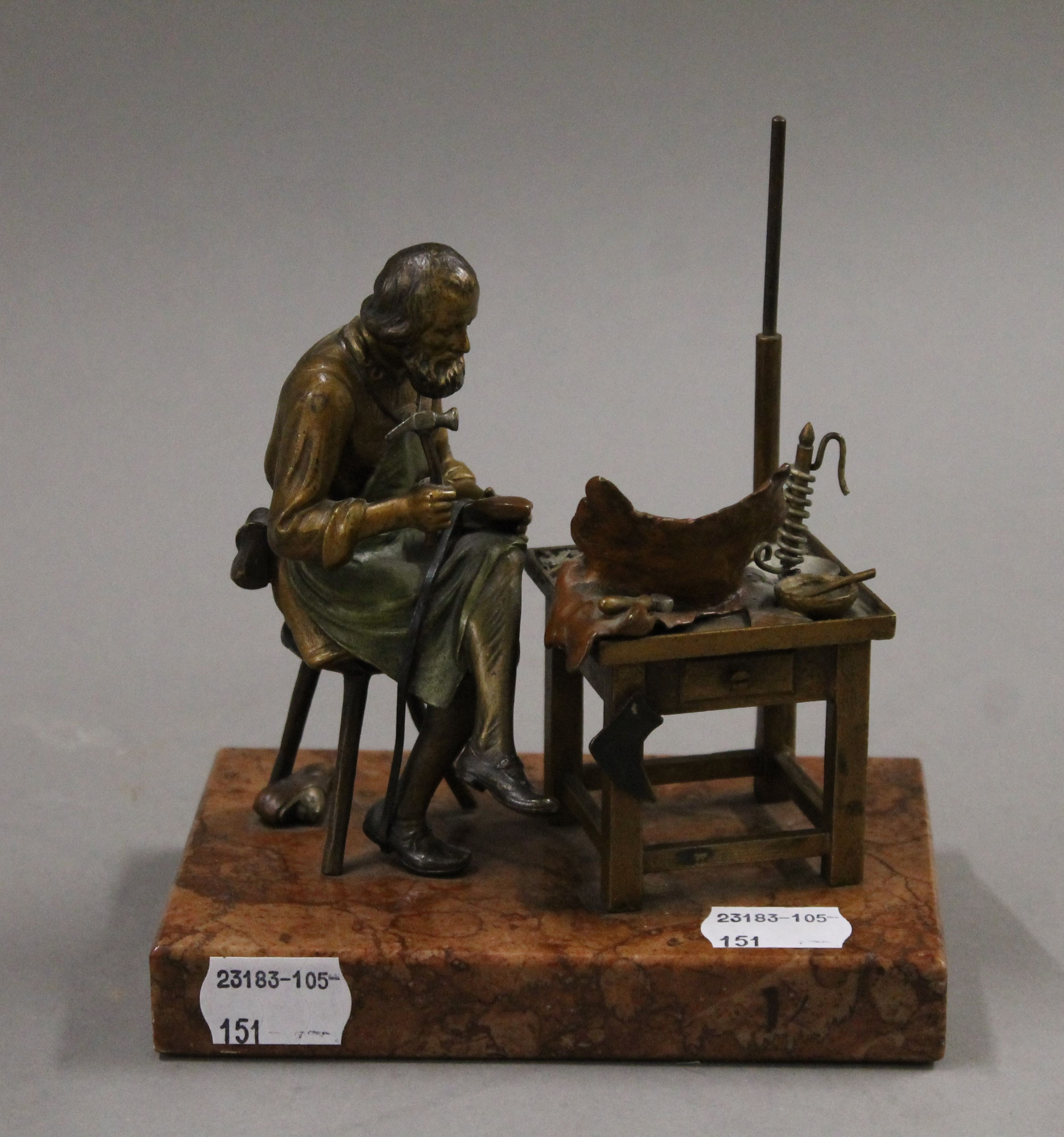 A cold painted bronze model of a cobbler mounted on a rouge marble base. 13.5 cm wide.