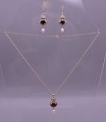 A 9 ct gold garnet, aquamarine and pearl pendant on chain with matching earrings. Pendant 3.