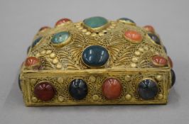 An Indian gilt box set with cabochon stones. 11 cm wide.