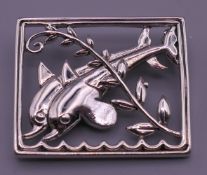 A sterling silver dolphin form brooch. 3.5 cm wide.