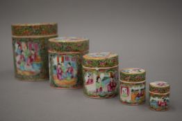 A set of 19th century Canton famille rose cylindrical boxes. The largest 11.75 cm high.