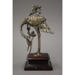 A Japanese silvered bronze model of a crane on a wooden plinth base. 18.5 cm high.