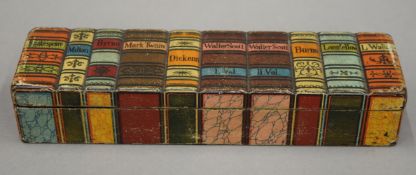 A papier mache pen box formed as a row of books. 20.5 cm long.