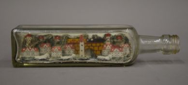 A model village in a bottle. 21.5 cm long.