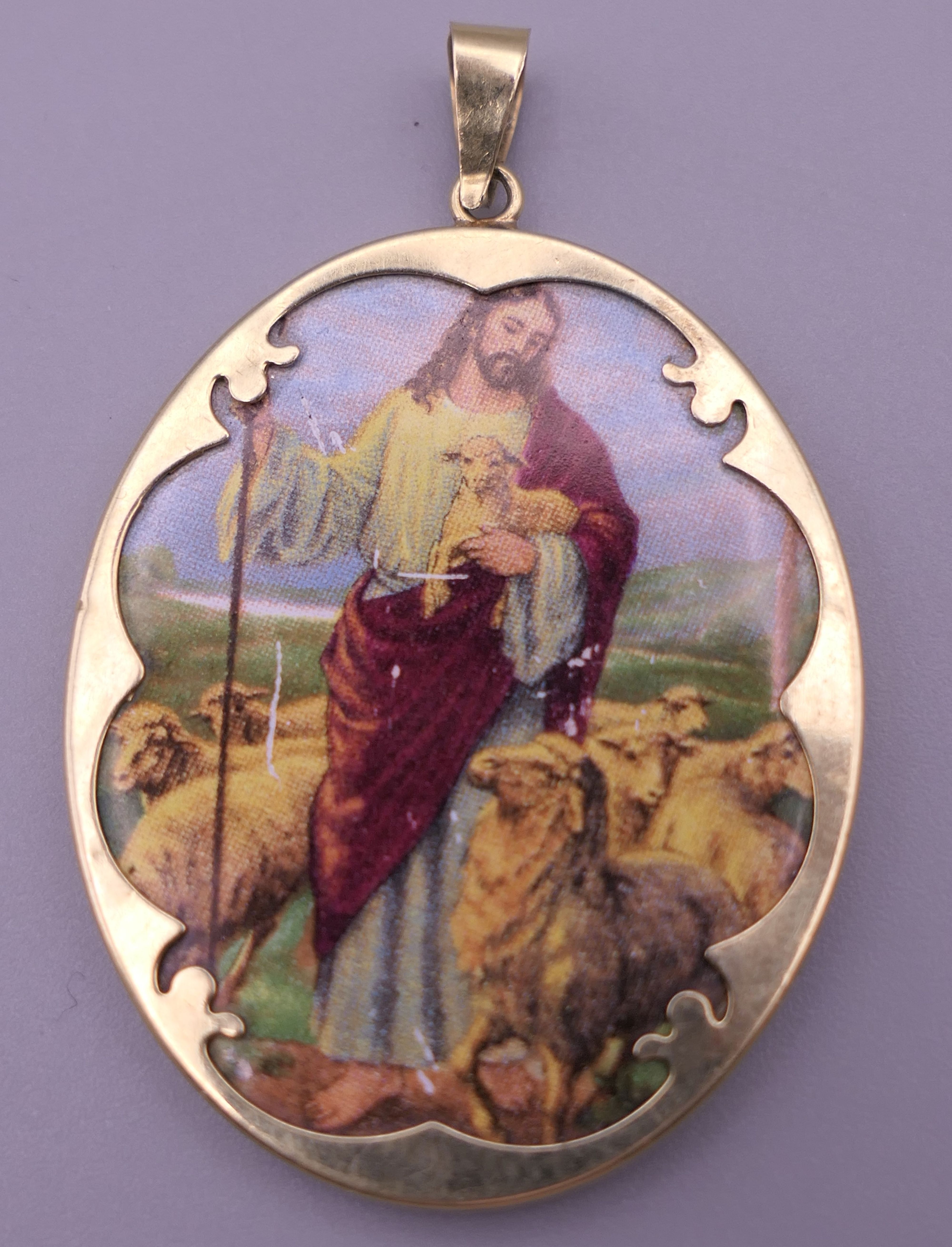 A 14 ct gold mounted pendant depicting Jesus. 4.5 cm high.