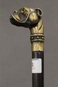 An ebony walking stick with brass dogs head handle. 89 cm long.