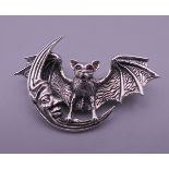 A sterling silver bat and crescent moon form brooch. 4.75 cm wide.