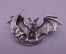 A sterling silver bat and crescent moon form brooch. 4.75 cm wide.