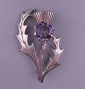 A silver and amethyst thistle form brooch. 4.5 cm high.