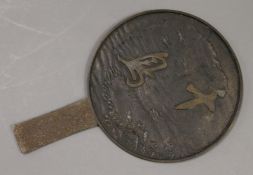 A Japanese bronze hand mirror. 27 cm high.