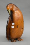 A carved wooden model of a penguin with brass beak. 33.5 cm high.