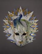 An unusual porcelain mask decorated with a peacock. 35 cm high.