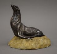 A silvered bronze model of a sea lion mounted on a naturalistic rocky base. 14.5 cm high.