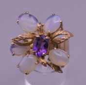 A 9 ct gold five stone moonstone ring with central amethyst. Ring size M/N. 6.