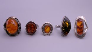 Five amber set silver rings.