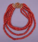 A coral bead necklace set with an 18 ct gold clasp. 42 cm long.