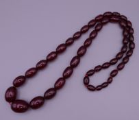 A cherry amber coloured necklace. 82 cm long. 89.2g.