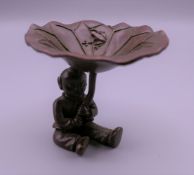 A bronze model of a Japanese boy holding a lily pad. 6 cm high.