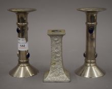 A pair of candlesticks and another. The former 16.5 cm high.