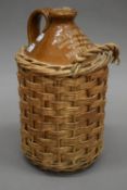 A Doulton Lambeth spirit flagon for Charles Hills Minster Place Ely, in original basket. 30 cm high.