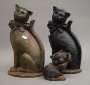 Two cast iron cat form doorstops and a companion set holder formed as a cat. The latter 38.