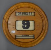 An early 20th century oak perpetual calendar. 31 cm diameter.