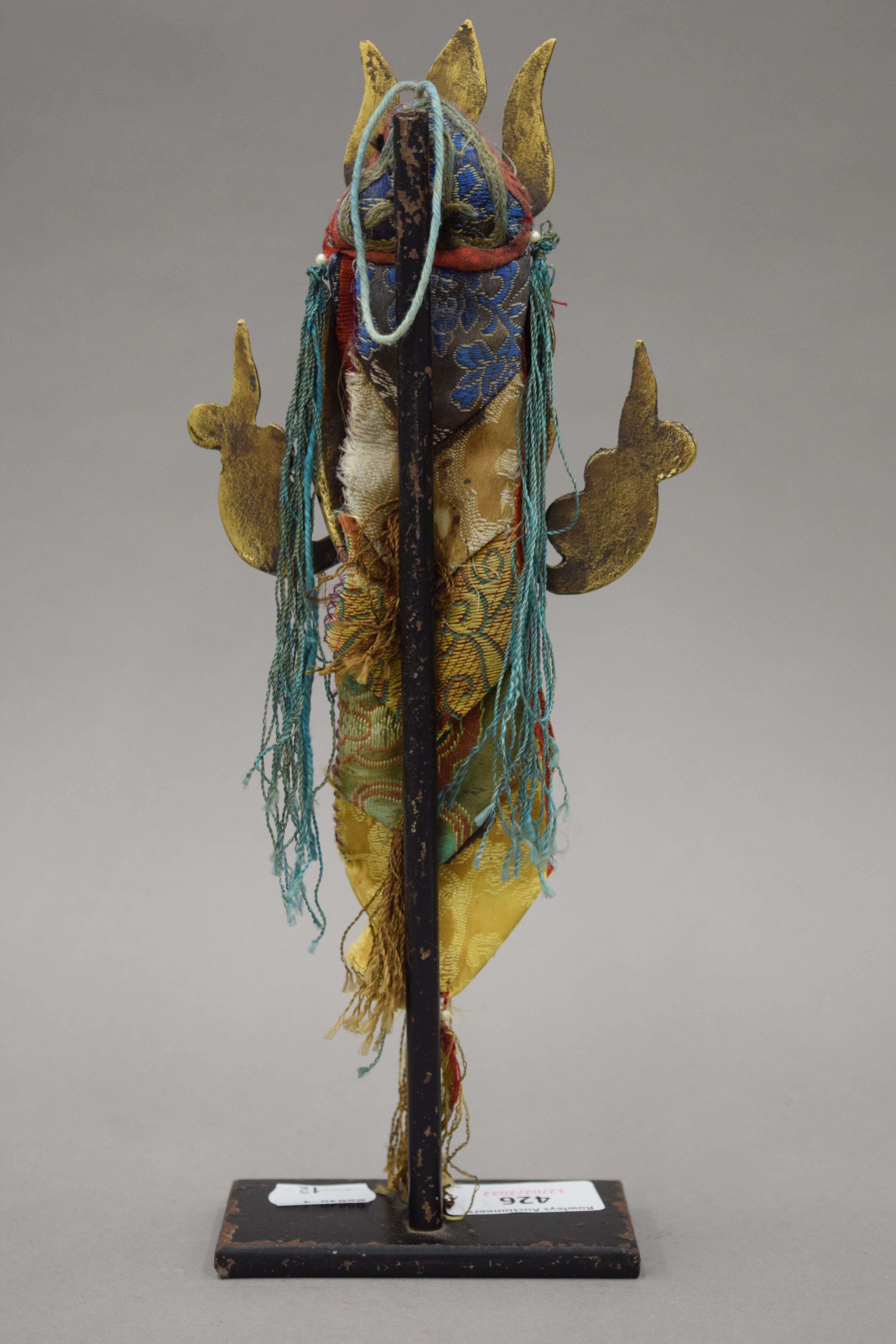 A 19th century Eastern bronze mask with textiles mounts, mounted on a display stand. 28. - Image 3 of 3