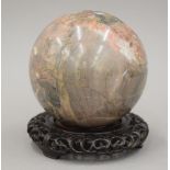 A marble specimen ball on a Chinese carved stand. 14 cm high.