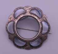 A Victorian white metal Scottish hardstone brooch with hand engraving. 4.5 cm diameter. 9.