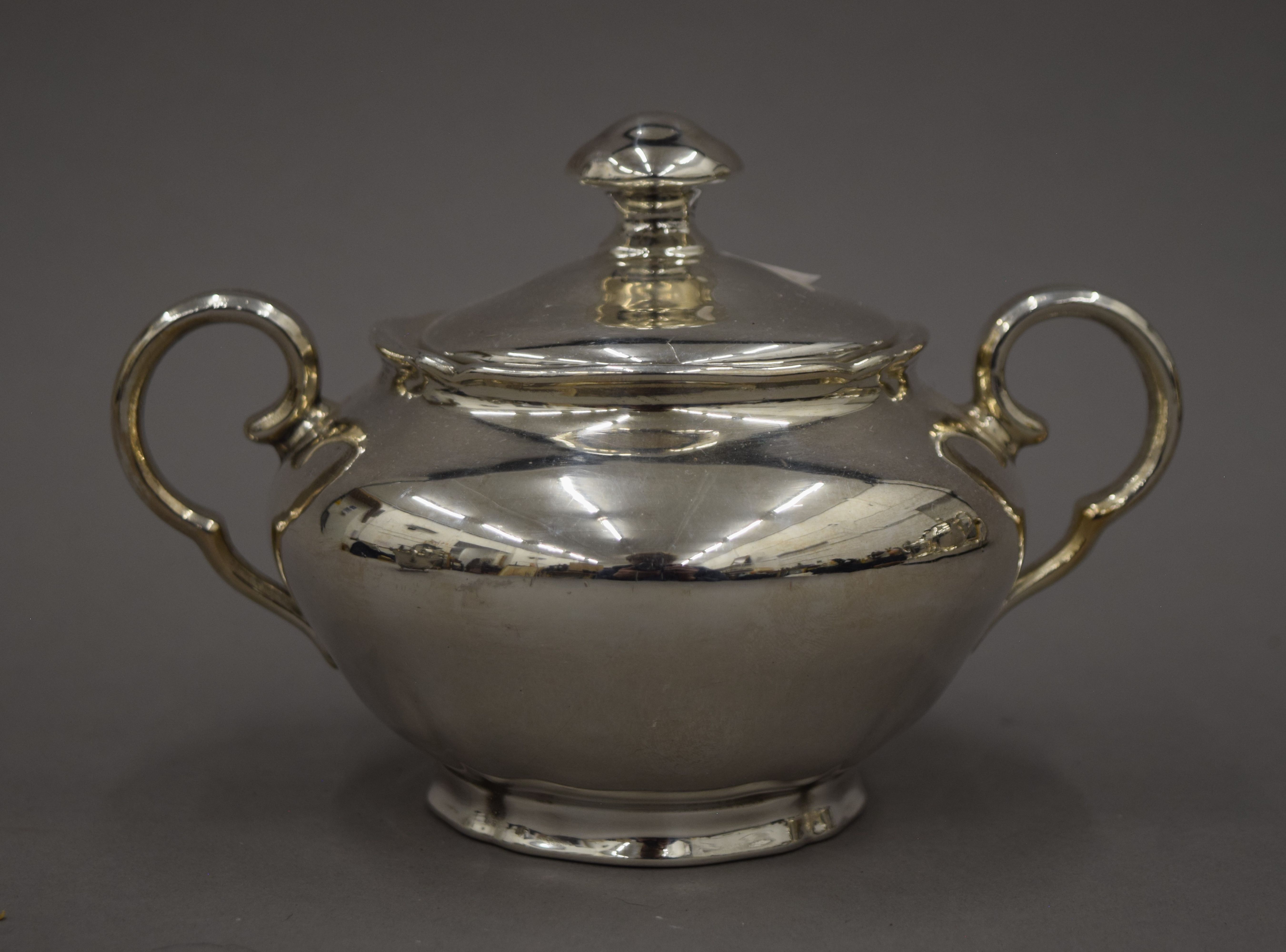 A three-piece silver plated tea set and a three-piece porcelain and silver overlaid tea set and an - Image 8 of 10