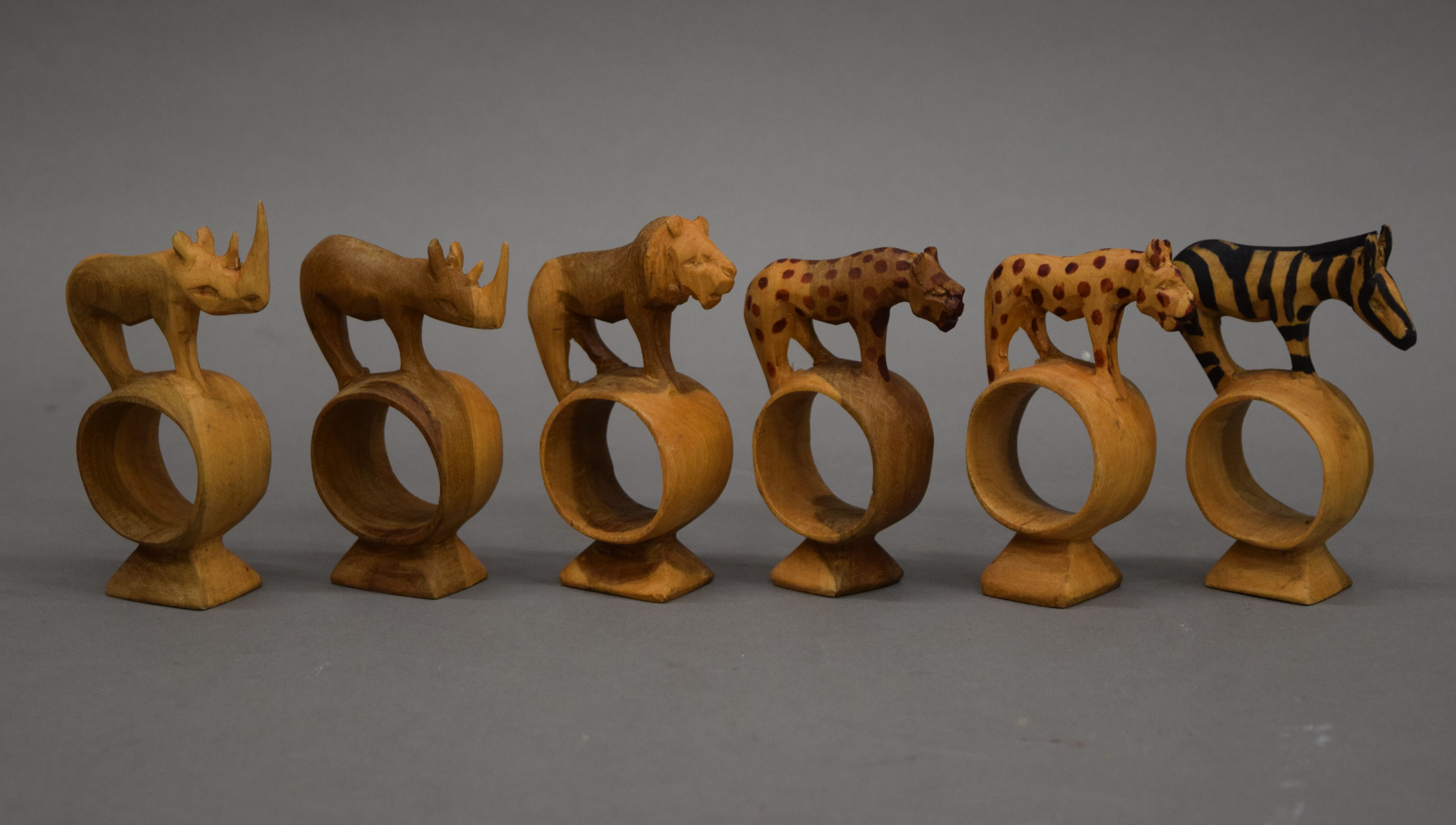 A set of napkin rings, each carved with an animal.