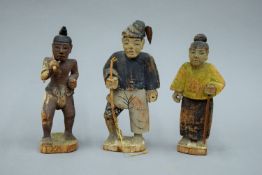 Three Eastern carved wooden figures. The largest 16.5 cm high.