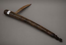 An African tribal weapon with carved figural finial. 59 cm long.