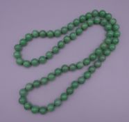 A string of Chinese apple green jade beads. 81 cm long.