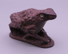 A wooden netsuke formed as a frog. 4 cm high.