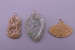 Three gold mounted jade pendants. The largest 4.5 cm high.