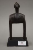 An African tribal carved wooden pully mounted on a display plinth. 21 cm high.