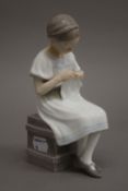 A Copenhagen model of a girl knitting. 17 cm high.