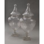 A pair of cut glass lidded urns. Each 54 cm high.