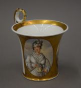 A Paris porcelain cup decorated with two figural vignettes. 12 cm high.