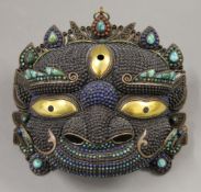 A Tibetan cabochon set copper and brass mask. 23 cm wide.