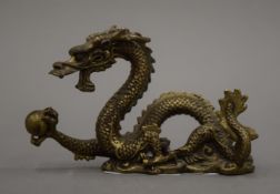 A Chinese gilt bronze dragon brush rest. 7 cm high.