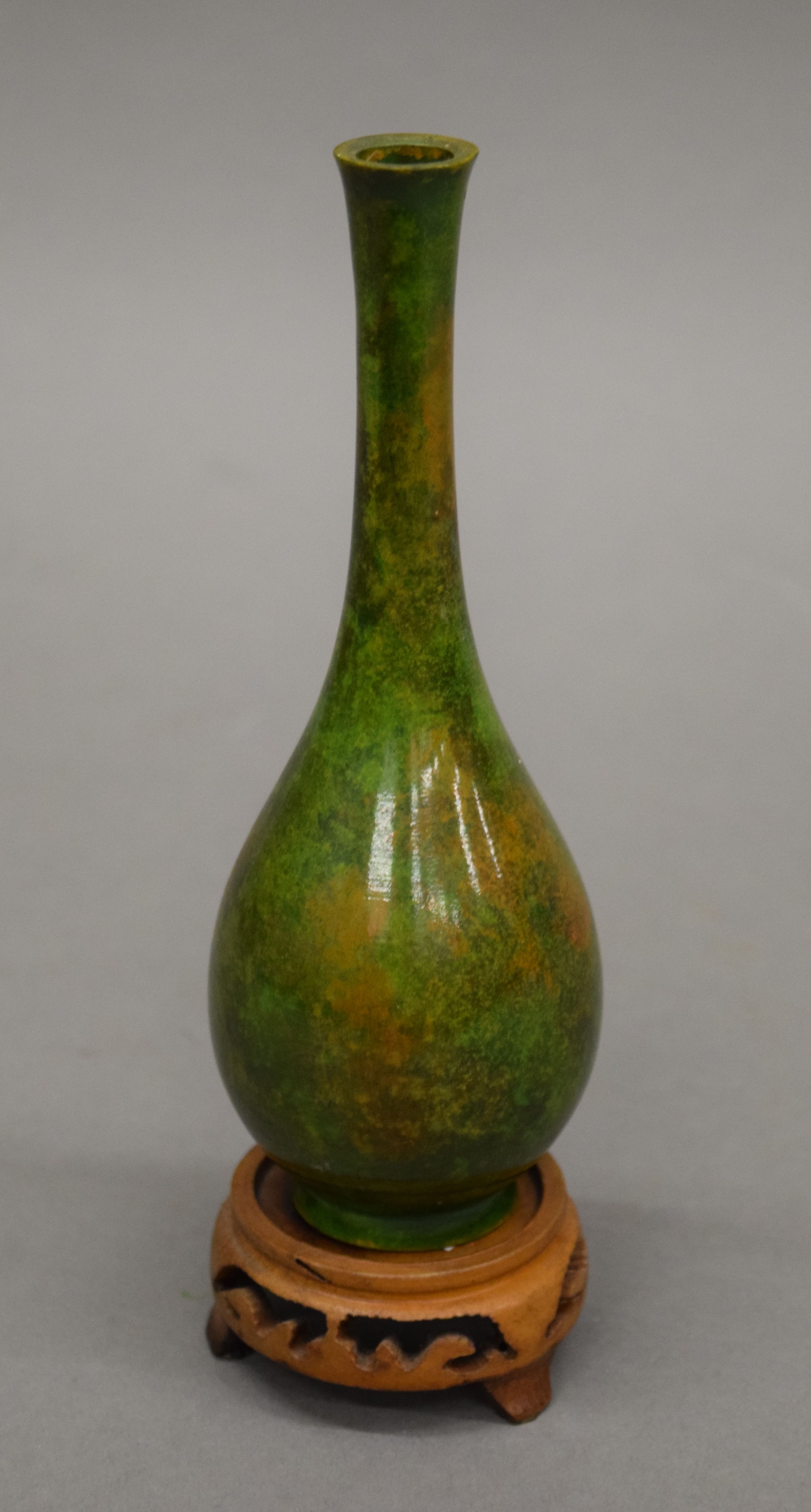 A small Japanese patinated bottle vase on a carved stand. 19 cm high overall.