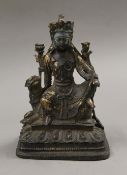 A bronze model of Buddha seated on a dog of fo. 22 cm high.